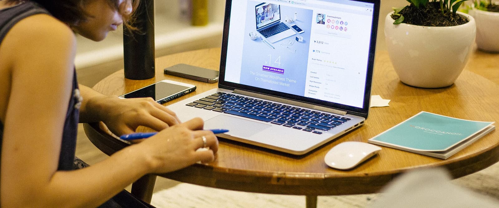Person arbeitet an einem Laptop an einem Tisch